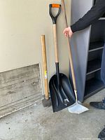 Sledgehammer, snow shovel, square shovel against wall