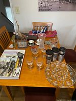 Overview of table showing glassware, flatware tray, travel mugs, platter and Conair mixer