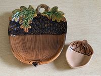 Large and small acorn-shaped ceramic trays side by side
