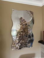 Full view of reflective stainless steel wall sculpture mounted on wall
