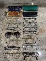 All eyeglasses, sunglasses, and cases laid out on countertop