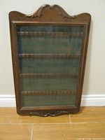 Front view of Bombay Company wooden spoon display cabinet with glass door closed