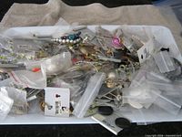 Tray showing numerous small bags and carded costume jewelry pieces