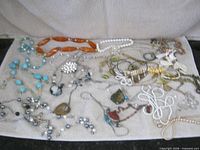 Overview of necklaces, pendants and chains spread on towel