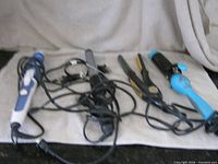 Four corded hair styling tools laid on towel