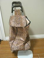 Front view of leopard print rolling shopping cart showing flap, handle and wheels