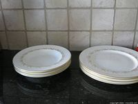 Stack of four 9 in soup bowls and four 10.5 in dinner plates on countertop