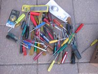 Pile of assorted screwdrivers with packaged file and wire wheel visible