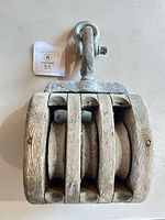 Front view showing three wooden sheaves and metal swivel