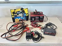 Group view of all chargers, booster cables and emergency kit