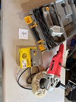 Overview of polisher, belt sander in case and sanding discs