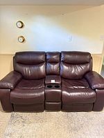 Front view of entire brown faux leather reclining loveseat