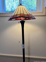 Full view of floor lamp showing stained glass shade and metal stem