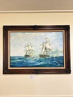 Full view of framed oil painting showing two ships at sea