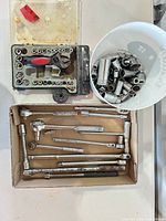 overall lot showing bit set case, bowl of sockets, box of accessories