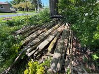 Stack of long weathered split-rail boards outdoors