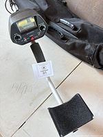 Full view of metal detector showing control housing, shaft and armrest