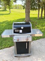 Front view of Weber Spirit E-210 grill with side shelves extended