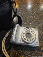Front view Canon PowerShot A540 with lens and wrist strap