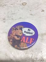 Front view of ALF button showing artwork and text