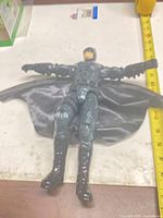 Full view of 12-inch Batman figure with tape measure for scale