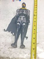 Full front view of Batman figure beside ruler showing height