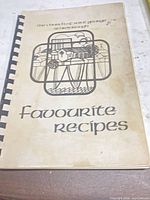 Front cover showing title, illustration, plastic comb binding, visible staining and wear