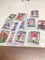 Overview of all twelve Panini Score football cards laid out on tabletop