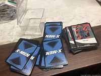 Loose X-Men TCG cards front and back plus plastic storage box