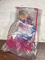 Front view of sealed Madame Alexander Alice doll in Happy Meal bag