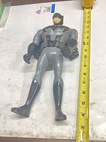 Full view of Batman figure beside measuring tape showing ~13 in length
