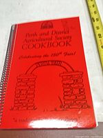 Front cover showing title, illustration, red colour, spiral binding