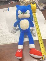 Front view of Sonic plush with measuring tape indicating ~12 in height