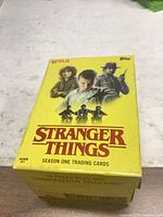 Front view of yellow Stranger Things Season One trading card box