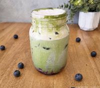 Matcha latte with blueberries in mason jar