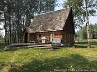 Exterior view of Heritage Farmhouse cabin amid trees and lawn