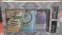 Front view of boxed Spa Luxetique epsom salts set showing three salt bags, tea tree oil bottle, scoop