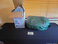 Boxed Aerobed and green carry bag on table
