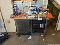 Overall view of Craftsman workbench and cabinet with contents on top