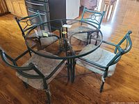 round glass table with four metal chairs around it