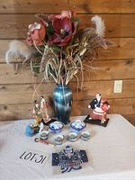 overall lot showing vase with floral arrangement, porcelain tea set pieces, dolls and accessories