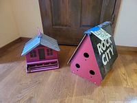 Both birdhouses side by side on floor