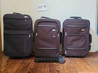 All three suitcases standing upright with folding cart laid in front