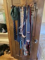 Ties, belts, green cap hung on door