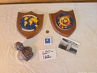 overview of all items: two plaques, coins, bust, photo