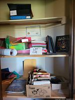 Overall view of both shelves showing binders, envelopes, folders, books, NuWave box