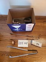 Box containing assorted stainless and wood kitchen utensils
