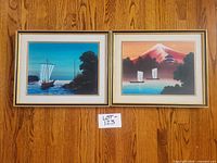 Both framed prints side by side on wood floor