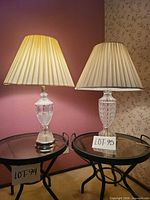 Pair of crystal table lamps on glass tables showing overall appearance and shades