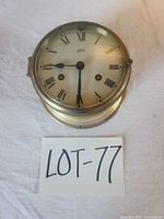 Front view of brass ship clock with lot tag visible